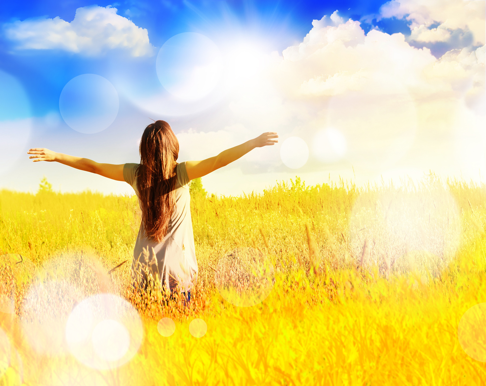 Free happy woman enjoys freedom on sunny meadow.