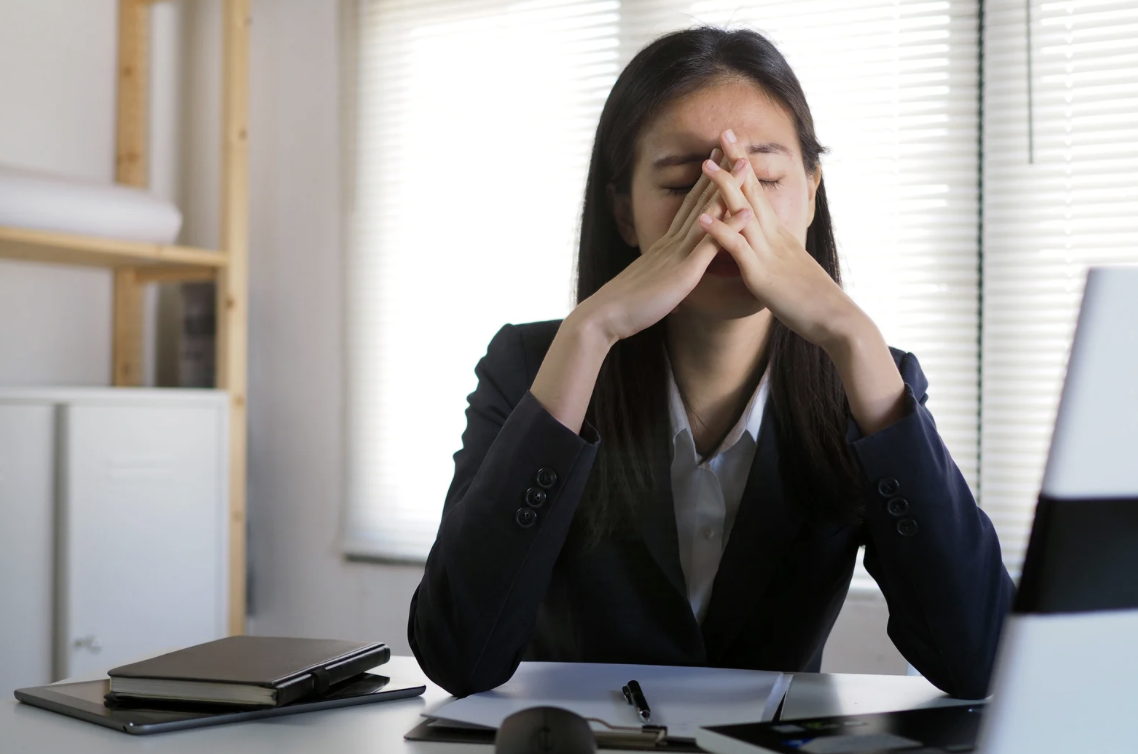 Woman at computer desk fatigued