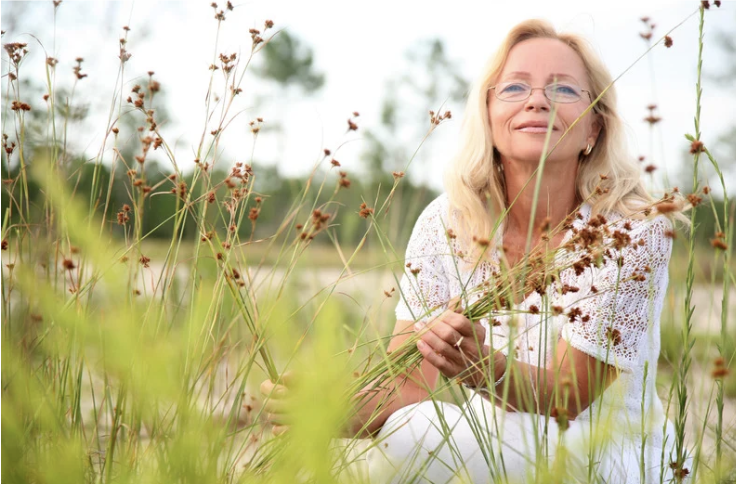 Woman in Fo=ield f wildflowers in Summer