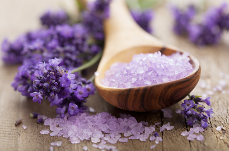 Lavender bath salts with a wooden scoop and fresh lavender sprigs for a relaxing Epsom salt bath